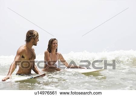 Guy and girl in water with surfboards laughing View Large Photo Image Stock Image - Guy and girl in water with surfboards laughing. Fotosearch