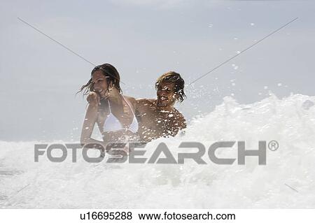 Guy and girl in wave, laughing View Large Photo Image Stock Photo - Guy and girl in wave, laughing. Fotosearch