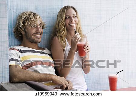 Guy and girl laughing with red smoothies View Large Photo Image Stock Photo - Guy and girl laughing with red smoothies. Fotosearch