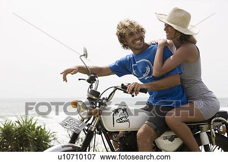 Guy and girl on motorbike laughing, ocean behind them View Large Photo Image Stock Photo - Guy and girl on motorbike laughing, ocean behind them. Fotosearch