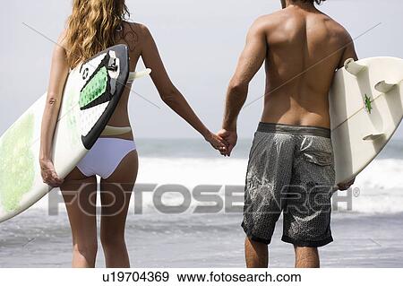Guy and girl walking with surfboards View Large Photo Image Stock Photo - Guy and girl walking with surfboards. Fotosearch