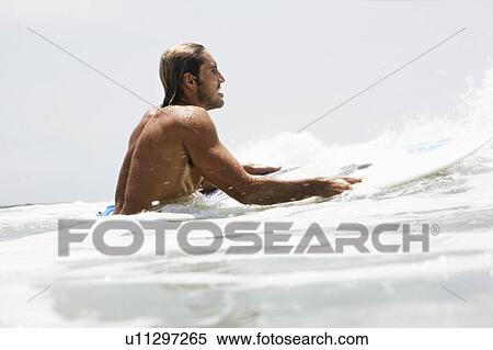 Stock Photography - Guy on surfboard waiting for wave. Fotosearch