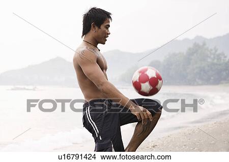 Guy playing football on beach View Large Photo Image Picture - Guy playing football on beach. Fotosearch