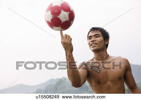 Stock Photo - Guy spinning football on finger. Fotosearch