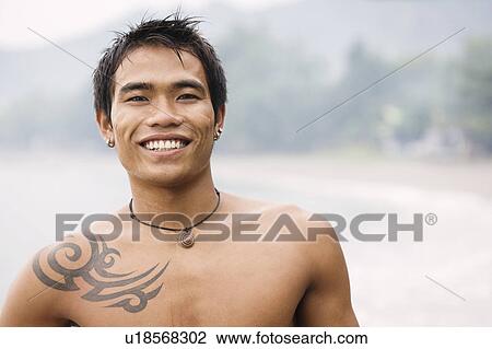 Stock Image - Guy with tatoo smiling to camera. Fotosearch