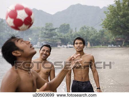 Guys playing football on beach View Large Photo Image Stock Photo - Guys playing football on beach. Fotosearch