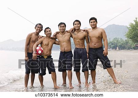 Picture - Guys posing for camera on beach. Fotosearch