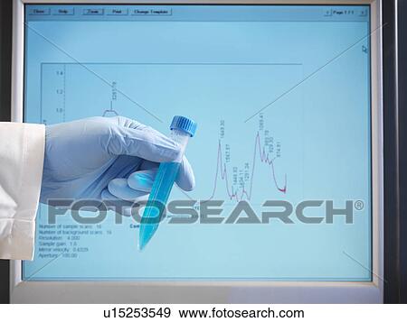 Stock Photo - Hand holding sample in front of monitor. Fotosearch
