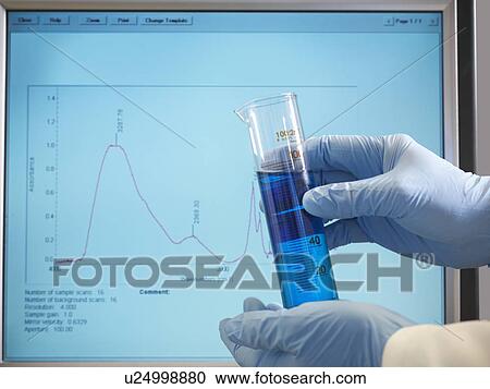 Stock Image - Hands holding sample in front of monitor. Fotosearch
