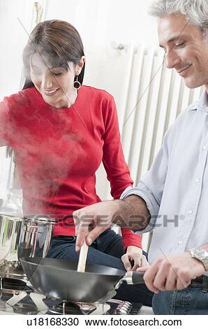 Happy couple cooking together at kitchen View Large Photo Image Stock Image - Happy couple cooking together at kitchen. Fotosearch