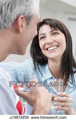 Picture - Happy couple drinking white wine. Fotosearch