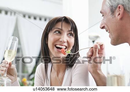 Happy couple feeding together at lunch View Large Photo Image Stock Photo - Happy couple feeding together at lunch. Fotosearch