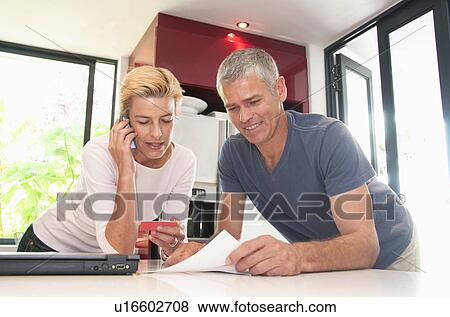 Happy couple pay bills with C card View Large Photo Image Stock Photo - Happy couple pay bills with C card. Fotosearch