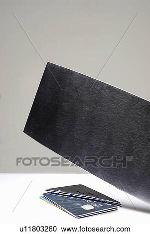 Stock Image - Hatchet cutting credit cards. Fotosearch
