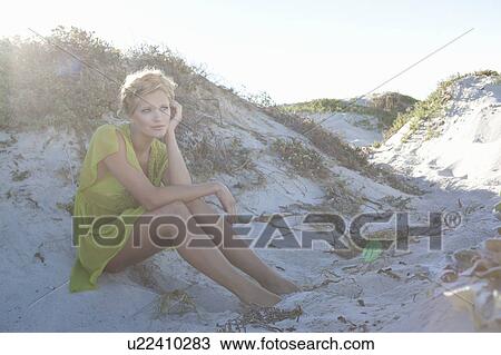 Stock Image - Head sitting in dunes. Fotosearch