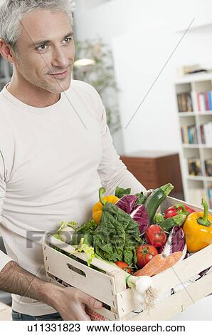 Stock Image - Healthy man with vegetables crate. Fotosearch