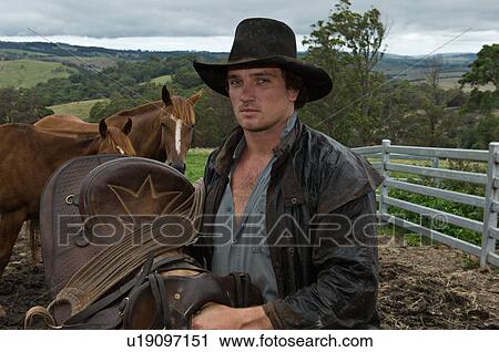 horse rider holding saddle with horses View Large Photo Image Stock Image - horse rider holding saddle with horses. Fotosearch