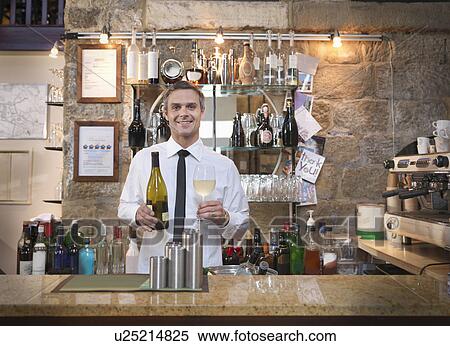 Stock Photography - Host offering wine in restaurant. Fotosearch