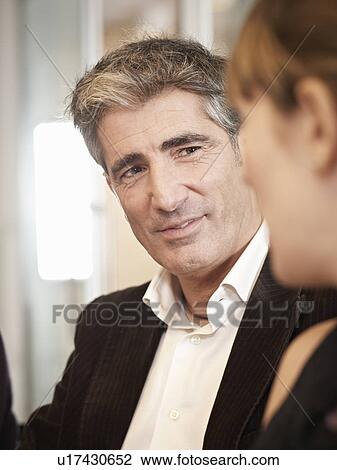 Stock Image - Individuals in a group meeting. Fotosearch