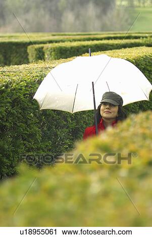 Lady with umbrella in maze View Large Photo Image Stock Image - Lady with umbrella in maze. Fotosearch
