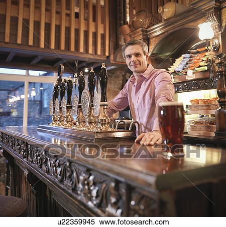 Stock Photography - Landlord in English pub. Fotosearch
