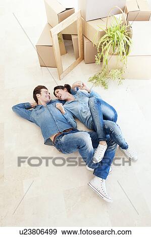 Stock Photo - Laughing couple laying on floor together. Fotosearch