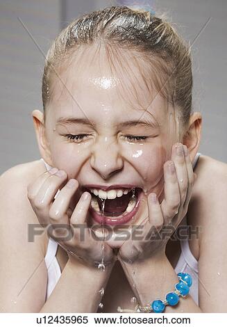 Stock Photography - Laughing girl washing her face. Fotosearch
