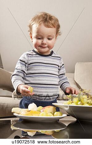 Little boy eating fruit View Large Photo Image Stock Photo - Little boy eating fruit. Fotosearch