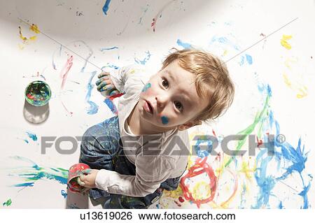 Stock Photograph - Little boy playing with finger paint. Fotosearch