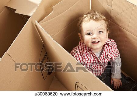 Little boy sitting in packing case View Large Photo Image Stock Image - Little boy sitting in packing case. Fotosearch