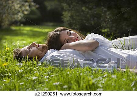 Stock Image - Love couple relaxing in a park. Fotosearch