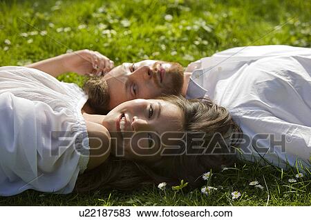 Love couple relaxing in a park View Large Photo Image Stock Image - Love couple relaxing in a park. Fotosearch