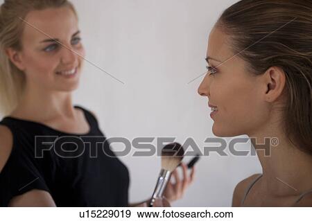 Stock Photo - Makeup artist applying blush to model. Fotosearch