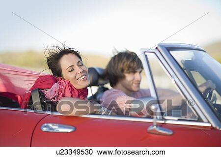 Man and woman driving in a convertible View Large Photo Image Stock Image - Man and woman driving in a convertible. Fotosearch