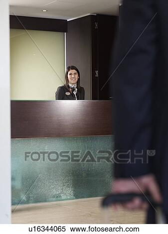 Stock Photography - Man aproaching front desk of a hotel. Fotosearch