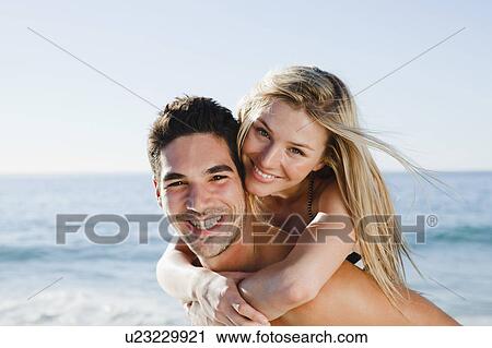 Man carrying girlfriend on beach View Large Photo Image Stock Image - Man carrying girlfriend on beach. Fotosearch