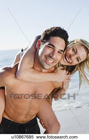 Man carrying girlfriend on beach View Large Photo Image Stock Photography - Man carrying girlfriend on beach. Fotosearch