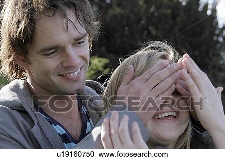 Man covering girlfriend’s eyes View Large Photo Image Stock Image - Man covering girlfriend’s eyes. Fotosearch