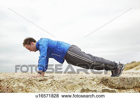 Man doing push ups outside on cloudy day View Large Photo Image Stock Photo - Man doing push ups outside on cloudy day. Fotosearch