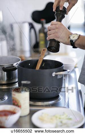 Man grinding pepper into pot View Large Photo Image Stock Image - Man grinding pepper into pot. Fotosearch