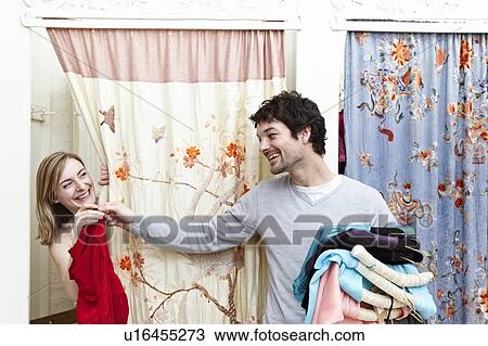 Man holding clothes by a changing room View Large Photo Image Stock Image - Man holding clothes by a changing room. Fotosearch
