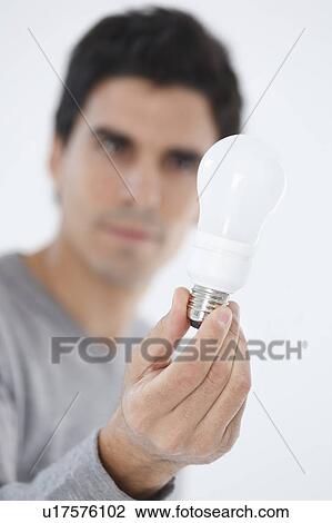 Stock Image - Man holding lightbulb. Fotosearch