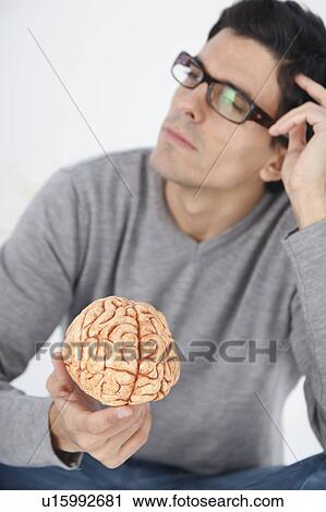 Man holding model brain, thinking View Large Photo Image Stock Image - Man holding model brain, thinking. Fotosearch