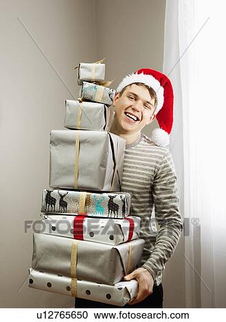 Man holding pile of christmas presents View Large Photo Image Stock Image - Man holding pile of christmas presents. Fotosearch