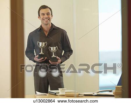 Man holding trophies View Large Photo Image Picture - Man holding trophies. Fotosearch