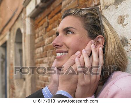 Stock Image - Man holding woman's face. Fotosearch