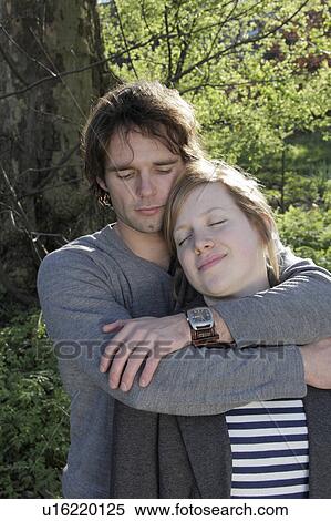 Man hugging girlfriend in park View Large Photo Image Stock Photography - Man hugging girlfriend in park. Fotosearch