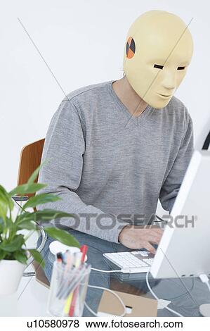 Man in crash dummy mask working at computer View Large Photo Image Stock Photo - Man in crash dummy mask working at computer. Fotosearch
