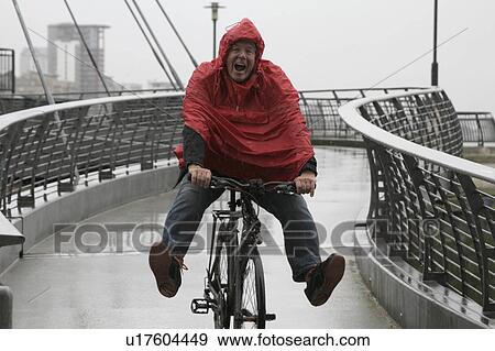 Stock Photo - Man in rain on bike having fun. Fotosearch