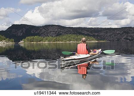 Man kayaking on calm lake View Large Photo Image Picture - Man kayaking on calm lake. Fotosearch